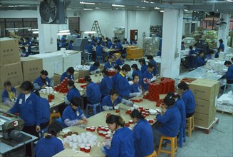 CHINA, Guangdong Province, Shenzhen, Female workers on floor of packaging factory.