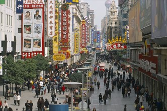 CHINA, Shanghai, Pedestrianised street crowded with shoppers and lined with advertising hoardings