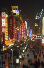 CHINA, Shanghai, Busy pedestrianised street with neon signs and advertising hoardings illuminated