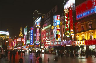 CHINA, Shanghai, Busy pedestrianised street with neon signs and advertising hoardings illuminated