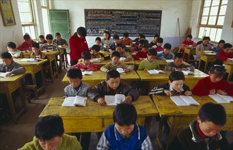 CHINA, Shaanxi Province, Xian, Classroom with school children reading at their desks with a teacher