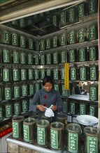 CHINA, Shaanxi Province, Xian, "Young woman serving a customer partly seen reflected in mirrored