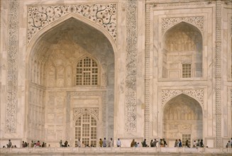 INDIA, Uttar Pradesh, Agra, "The Taj Mahal, detail of patterned marble walls with visitors below."