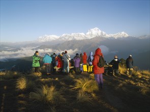 NEPAL, Annapurna Region, Poon Hill, Trekkers gathered to watch the sunrise over the Annapurna