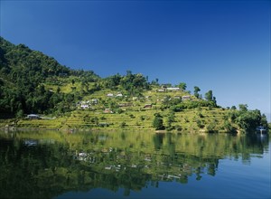 NEPAL, Annapurna Region, Pokhara, View over Lake Phewa with reflected terraced hillside with houses