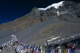 NEPAL, Annapurna Region, Thorung La Pass, Prayer flags hanging at the top of the pass with snow
