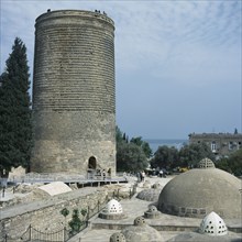 AZERBAIJAN, Baku, Icheri Shahar, Maidens Tower.  Circular stone tower with visitors standing on the