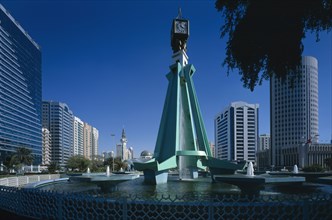 UAE, Abu Dhabi, City centre clock tower with fountain underneath modern structure.  High rise