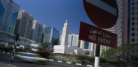 UAE, Abu Dhabi, City centre mosque surrounded by modern high rise buildings with speeding traffic