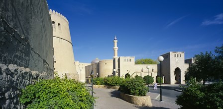 OMAN, Nizwa, "Town centre with crenellated walls surrounding quiet, open, paved area with raised