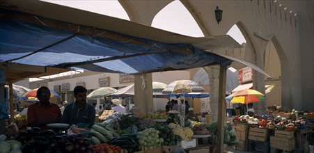 OMAN, Muscat, Mutrah produce market.  Covered stalls beside arched entrance with displays of fruit