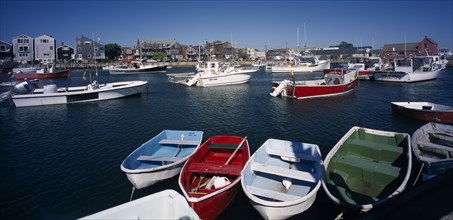 USA, Maine, Rockport, View over painted wooden rowing boats towards waterside buildings.