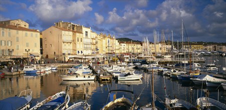 FRANCE, Provence-Cote d’Azur, St Tropez, View over harbour with boats moored beside wooden jetties