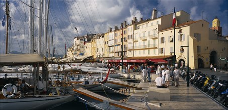 FRANCE, Provence-Cote d’Azur, St Tropez, "View along busy waterfront  with boats moored at the