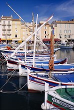 FRANCE, Provence-Cote d’Azur, St Tropez, View along line of moored boats towards waterside