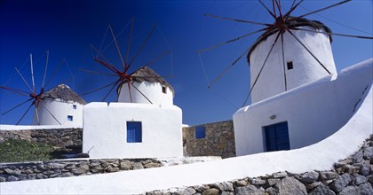 GREECE, Cyclades Islands, Mykonos, Three white painted windmills against blue sky.
