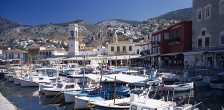GREECE, Saronic Islands, Hydra, Hydra Town.  Harbour with moored boats and town on hillside behind.