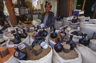 ETHIOPIA, Gojam Province, Markets, Female vendor behind display of sacks of cereals and pulses for