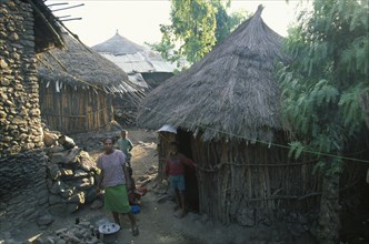 ETHIOPIA, Wolo Province, Lalibela, Young woman and children outside circular wooden house with