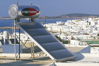 GREECE, Cyclades Islands, Energy, Solar powered water heater on rooftop.