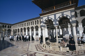 SYRIA, South, Damascus, The Umayyad Mosque.  The ablutions fountain with pilgrims sitting around