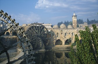 SYRIA, Central, Hama, Wooden norias or waterwheels on the Orontes river and the Al-Nuri Mosque