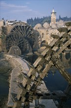 SYRIA, Central, Hama, Wooden norias or waterwheels on the Orontes river and the Al-Nuri Mosque