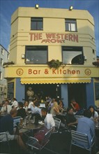 ENGLAND, East Sussex , Brighton, City bar and restaurant with open front and people sitting at