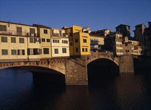 ITALY, Tuscany, Florence, "Ponte Vecchio, the west side in warm, golden light with people standing