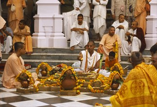 INDIA, Utter Pradesh, Vrindaven, Monks and worshippers on temple steps.   Dirwali festival?