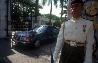 MALAYSIA, Kuala Lumpur, The Kings Palace.  Guard in uniform outside palace gates with official car