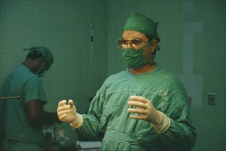CUBA, Havana, Doctor in theatre greens and sterile gloves ready to perform operation
