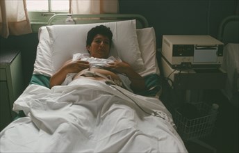 CUBA, Havana, Pregnant mother in hospital bed attached to monitor