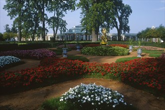 RUSSIA, St. Petersburg, Peterhof Palace grounds.  View over formal gardens and borders with red and