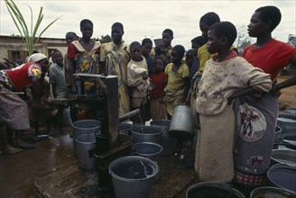 MALAWI, People, Women and children crowded around water pump with buckets.