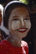 MYANMAR, Children, Single Girls, Smiling young girl wearing thanaka paste on her face in