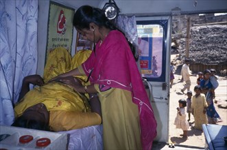 INDIA, Karnataka, Bangalore, Female health worker examining a pregnant woman in a mobile clinic.