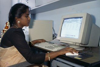 INDIA, Karnataka, Bangalore, Young Indian woman using computer.