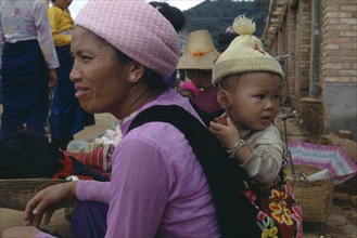 CHINA, Yunnan, Menghun, Dai mother with child on her back