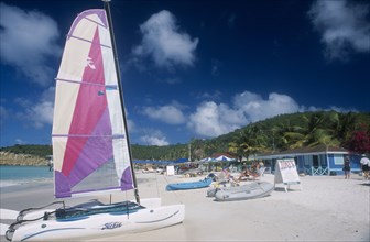 WEST INDIES, Antigua, Dickenson Bay, "Sandy beach with people on deck chairs beside blue painted