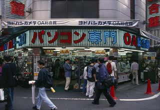 JAPAN, Honshu, Tokyo, Electrical store open to the street with people walking past