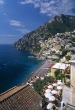 ITALY, Campania, Positano, View over balcony with tables and chairs under white sun umbrellas