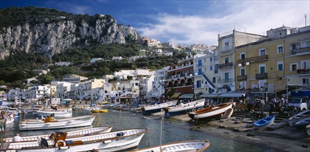 ITALY, Campania, Capri, Marina Grande.  View over moored boats in harbour lined with colourful