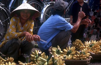 VIETNAM, Mekong Delta, Can Tho, Woman selling bananas from woven baskets.