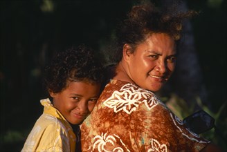 PACIFIC ISLANDS, Cook Islands, Aitutaki , Near Vaipae. Portrait of smiling mother and daughter
