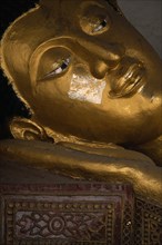 THAILAND, North, Chiang Mai, Wat Chedi Luang. Face of reclining Buddha with gold leaf on the face