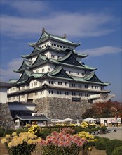 JAPAN, Honshu, Nagoya, The Castle with floral gardens in the foreground and small cabin with tables