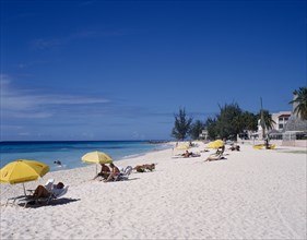 BARBADOS, South Coast, Dover Beach. , "Golden sandy beach lined with palms, with scattered bathers,