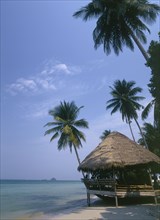 THAILAND, Trat Province, Koh Chang, Kai Bae Beach with thatched hut restaurant at the waters edge.