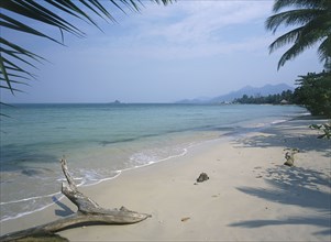 THAILAND, Trat Province, Koh Chang, Kai Bae Beach view along sandy beach and coast framed by palm